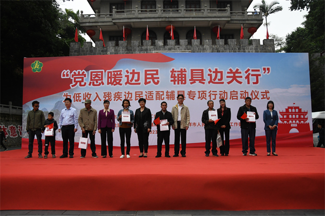 图为出席活动领导向受助残疾人发放辅具 图为出席活动领导向受助残疾人发放辅具