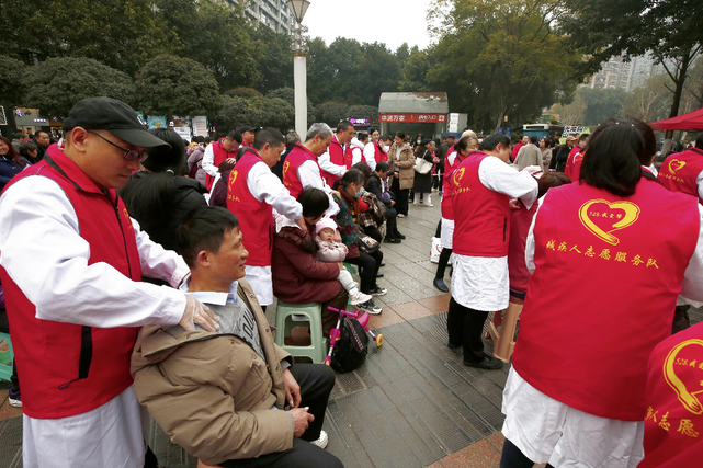 图为盲人按摩师免费为群众进行按摩