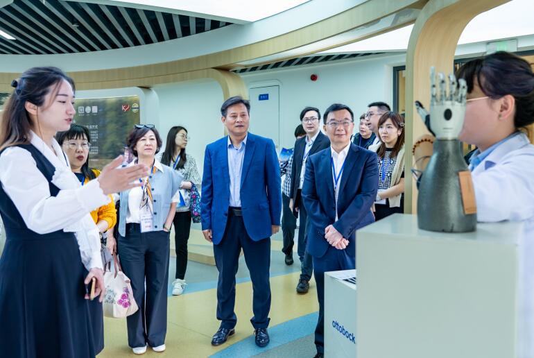 图为工作人员向澳门社会服务团体负责人交流团介绍展示辅具