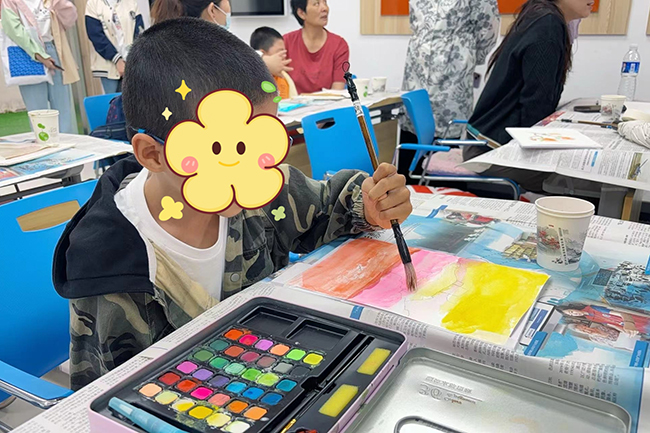 图为脑瘫儿童在教室里制作水彩画