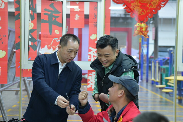 图为黄进良(左)在浏阳市凝馨残疾人服务中心与托养对象交流