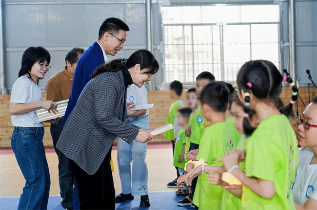 图为参加活动嘉宾为在训儿童赠送礼物