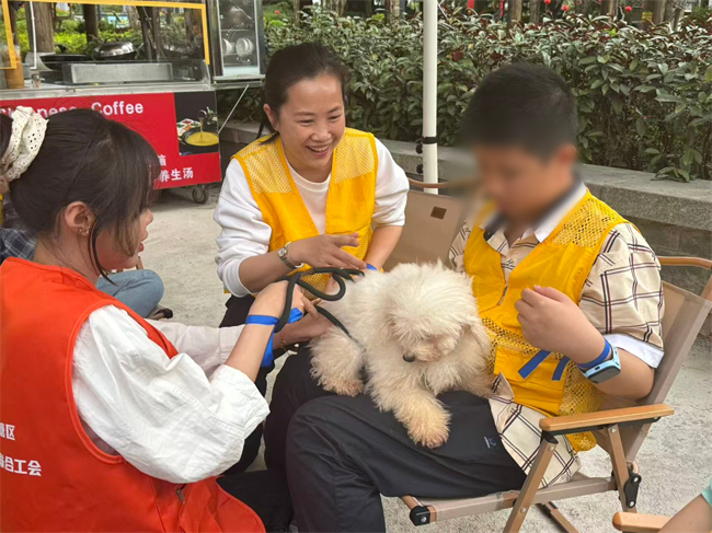图为在训儿童与专业情绪抚慰犬互动